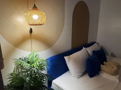a room with a couch with a lamp and a plant at Shore Residences near Airport Blueberry Room 2 Beds Pool View by Prime Stay Room 628 in Manila