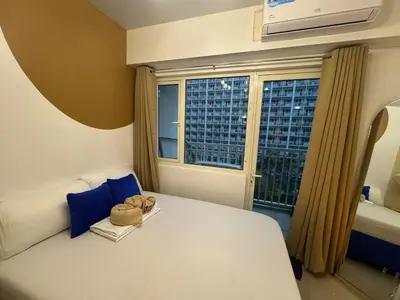 a bedroom with a bed with a stuffed animal sitting on it at Shore Residences near Airport Blueberry Room 2 Beds Pool View by Prime Stay Room 628 in Manila