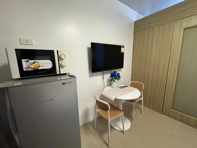 a small room with a small table and a television at Shore Residences near Airport Blueberry Room 2 Beds Pool View by Prime Stay Room 628 in Manila