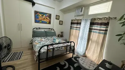 a small bedroom with a bed and a window at Seb and Santi Holland Park Staycation in Biñan
