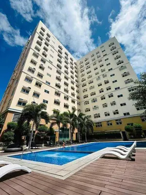 a large building with a pool in front of it at Seb and Santi Holland Park Staycation in Biñan