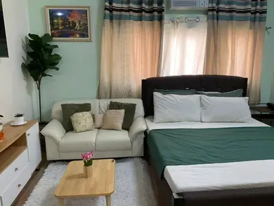 a living room with a bed and a couch at Seb and Santi Holland Park Staycation in Biñan