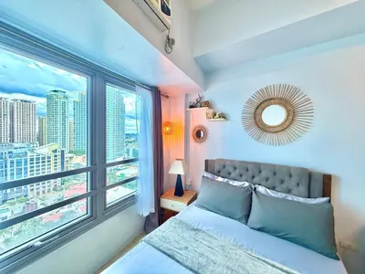 a bedroom with a bed and a large window at Pod to Go in Manila