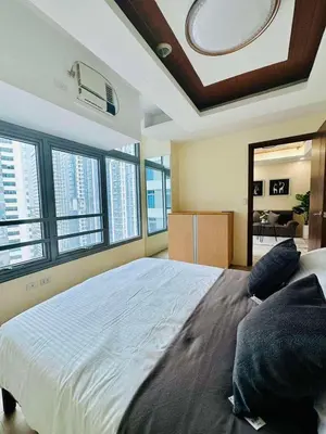 a bedroom with a large bed in a room with windows at Pod to Go in Manila