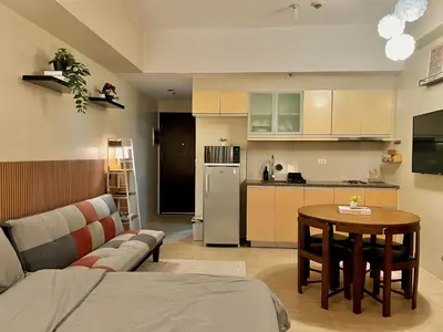 a living room with a couch and a table and a kitchen at Pod to Go in Manila