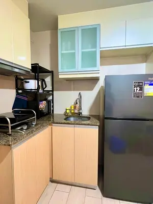 a kitchen with a refrigerator and a sink at Casa Haraya Urban Stays - Walking Distance to NAIA Terminal 3 Newport City Condo with 500mbps WIFI and free Netflix access in Manila