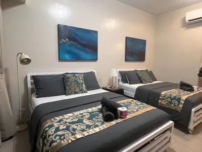 two beds in a room with two bedsitures at Casa Haraya Urban Stays - Walking Distance to NAIA Terminal 3 Newport City Condo with 500mbps WIFI and free Netflix access in Manila