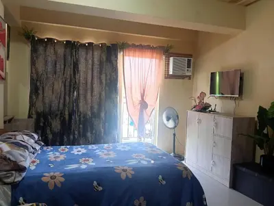 a bedroom with a bed with a blue comforter and a window at Deviente's Guesthouse in Manila