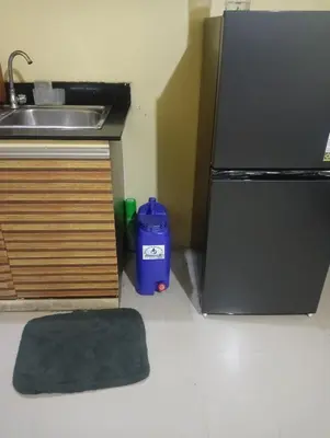 a kitchen with a sink and a refrigerator at Deviente's Guesthouse in Manila