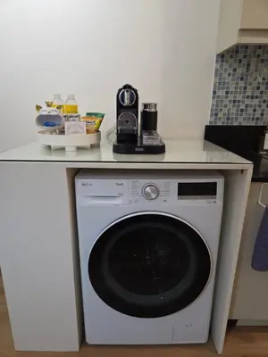a washing machine under a counter in a kitchen at Sparkling Shell Residences Kaeri Properties in Manila