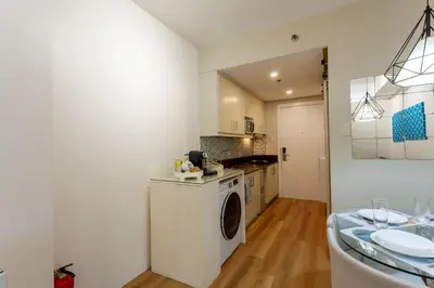 a kitchen with a washing machine in a room at Sparkling Shell Residences Kaeri Properties in Manila