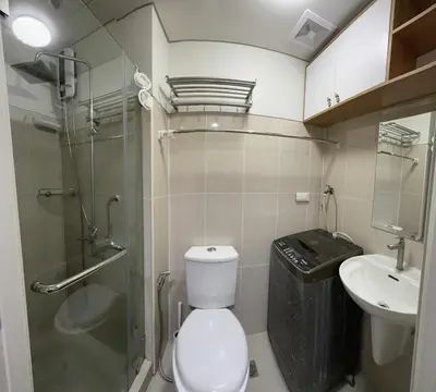 a bathroom with a toilet and a shower and a sink at Staycation, Mall of Asia in Manila