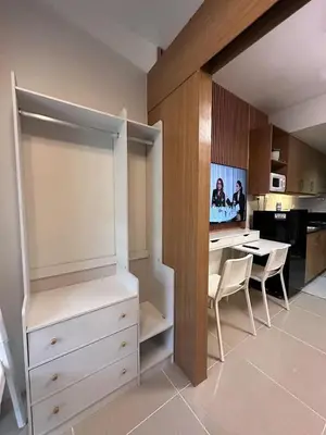 a kitchen with a desk and a table with chairs at Staycation, Mall of Asia in Manila