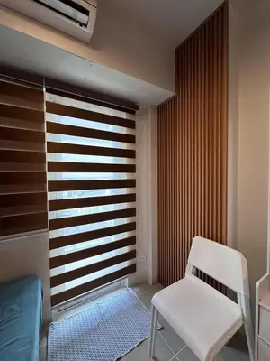 a room with a white chair and a window at Staycation, Mall of Asia in Manila