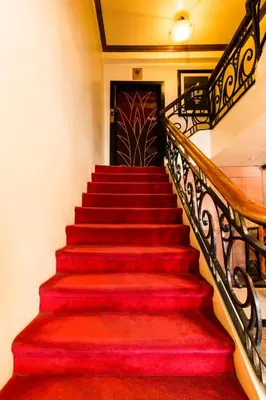 a staircase with red carpet and a black door at Miramar Hotel in Manila
