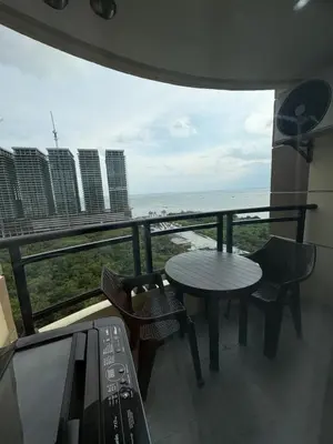 a balcony with a table and chairs and a view of the ocean at Sybay suites beside okada manila near AirPort MOA COD MSV1807H in Manila