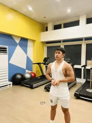 a man standing in a gym with his arms crossed at JFam Suites, C4-11K Studio, Up To 4 Pax in Biñan