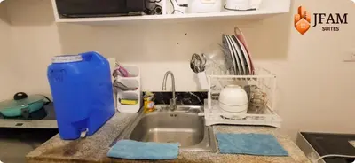 a kitchen sink with a blue container next to it at JFam Suites, C4-11K Studio, Up To 4 Pax in Biñan
