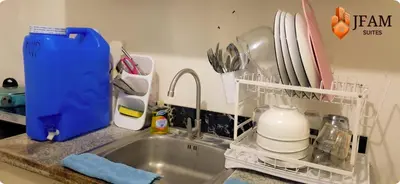 a kitchen sink with a dish drying rack next to it at JFam Suites, C4-11K Studio, Up To 4 Pax in Biñan