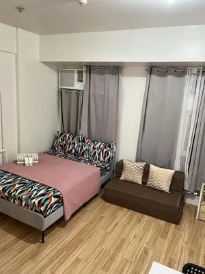 a bedroom with a bed and a couch at JFam Suites, C4-11K Studio, Up To 4 Pax in Biñan