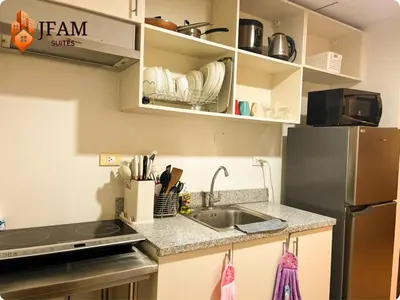 a kitchen with a sink and a refrigerator at JFam Suites, C3-9D Studio, Up To 4 Pax in Biñan