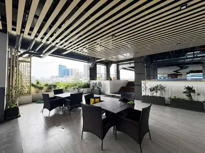 a restaurant with tables and chairs in a building at Modern 1 bedroom w Pool and City Views in Manila