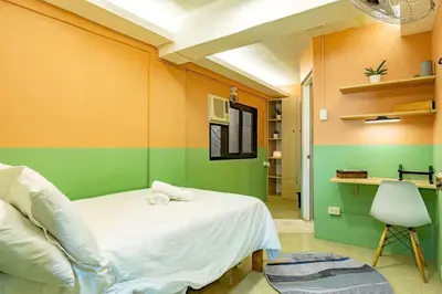 a bedroom with green and orange walls and a bed at Economy Room with Private Bath near LRT Santolan Pasig in Manila