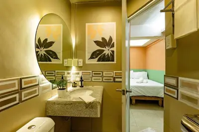 a bathroom with a sink and a mirror and a bed at Economy Room with Private Bath near LRT Santolan Pasig in Manila