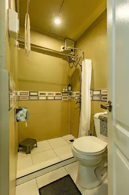 a small bathroom with a toilet and a shower at Economy Room with Private Bath near LRT Santolan Pasig in Manila