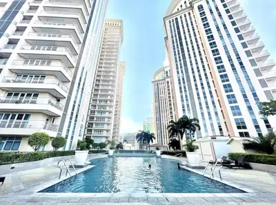 a swimming pool in the middle of two tall buildings at AdahkuMaya Luxury Suites in Manila
