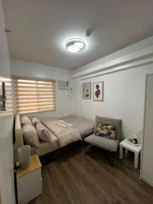 a bedroom with a bed and a chair in it at Mysuites2go 517 Lenden in Manila
