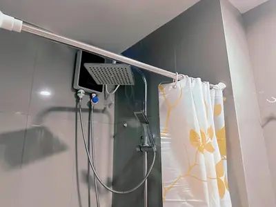 a shower in a bathroom with a shower curtain at Makati City Ph SnowWhite Staycation in Manila