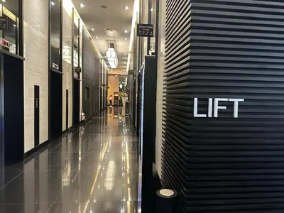 a hallway with a lift sign on the side of a building at Makati City Ph SnowWhite Staycation in Manila