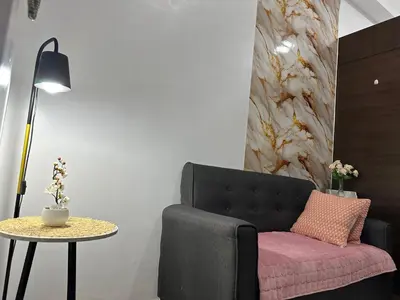 a living room with a black chair and a table at Makati City Ph SnowWhite Staycation in Manila
