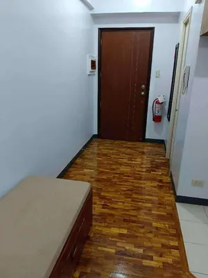 a room with a bed and a hallway with a door at The orienthal place, Makati a1 in Manila