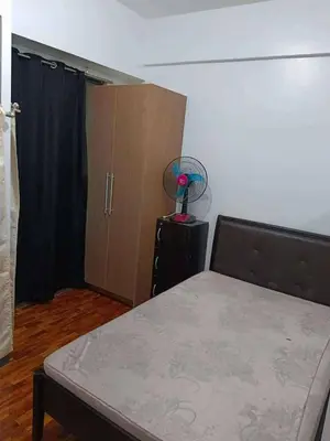 a bedroom with a bed and a closet with a fan at The orienthal place, Makati a1 in Manila