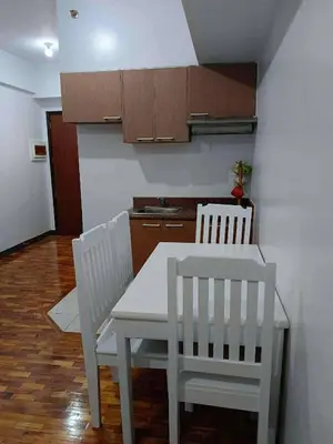 a kitchen with a white table and two white chairs at The orienthal place, Makati a1 in Manila