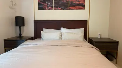 a bedroom with a large bed with two night stands at The Olive Place, Manadaluyong City in Manila
