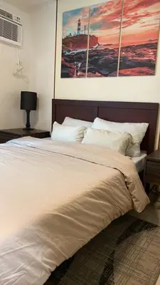 a bedroom with a large bed with white pillows at The Olive Place, Manadaluyong City in Manila