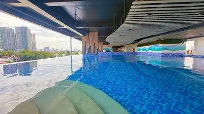 a large swimming pool in a building with a city at Harbour Park Residences Cozy 1BR Suite in Manila