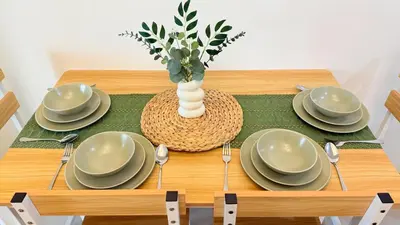 a table with plates and a vase on top of it at Harbour Park Residences Cozy 1BR Suite in Manila