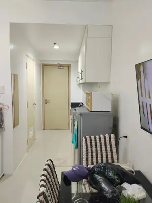 a living room with a table and a kitchen at Sea Residences Crisha in Manila