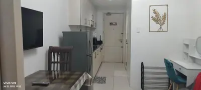 a kitchen with a refrigerator and a table and a chair at Sea Residences Crisha in Manila