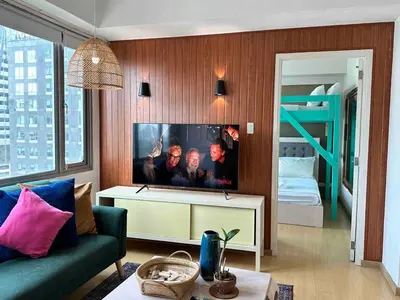 a living room with a tv and a couch and a bed at Cozy House BGC 1BR up to 6 Guests 100MBPS WiFi in Manila