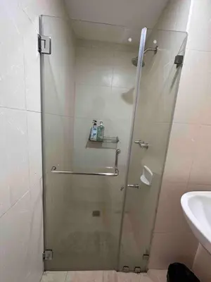 a shower with a glass door in a bathroom at Cozy House BGC 1BR up to 6 Guests 100MBPS WiFi in Manila