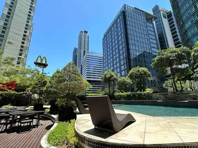 a pool with a table and chairs in a city at Cozy House BGC 1BR up to 6 Guests 100MBPS WiFi in Manila