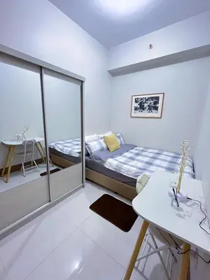 a bedroom with a bed and a desk and a table at Amber's Crib in Manila