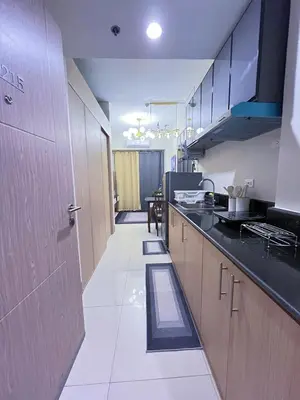 a kitchen with wooden cabinets and a counter top at Amber's Crib in Manila