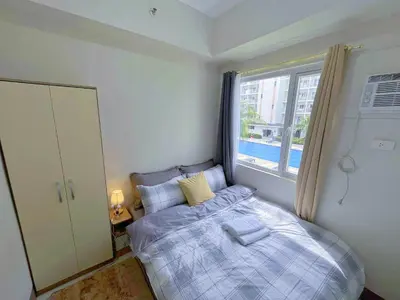 a small bedroom with a bed and a window at Amber's Crib in Manila