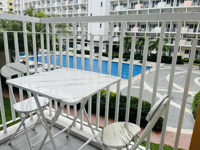 a white table and chairs on a balcony at Amber's Crib in Manila
